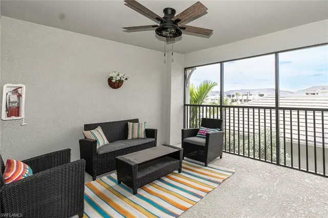 a living room with furniture and a floor to ceiling window