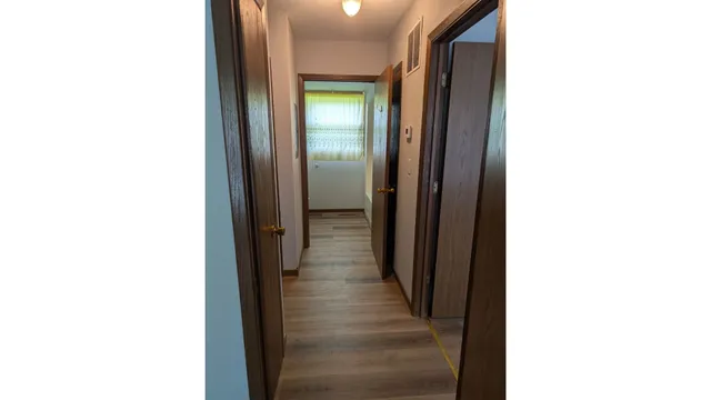 a view of a hallway with wooden floor