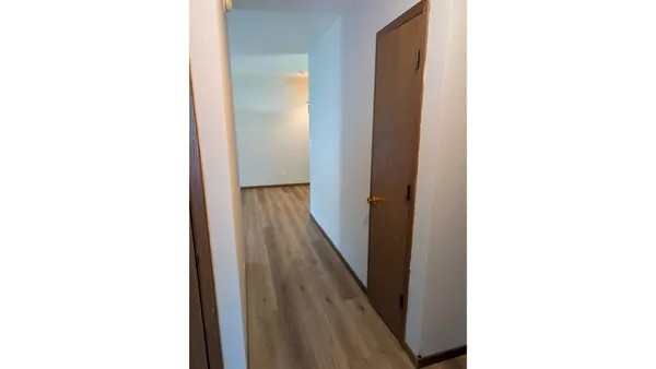 a view of a hallway with wooden floor