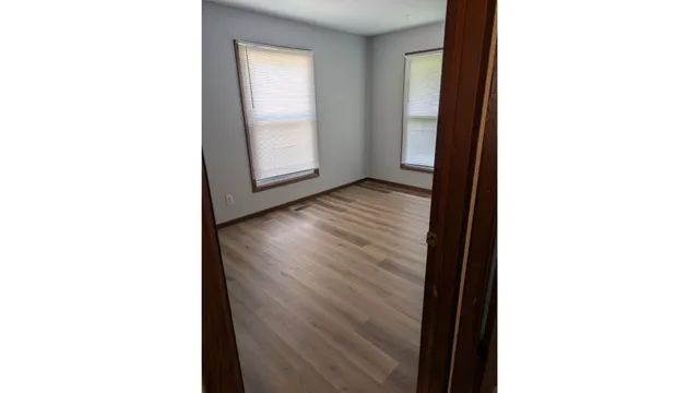 a view of a room with a window and hardwood floor