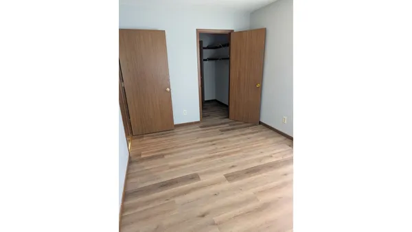 a view of a room with a door and a refrigerator
