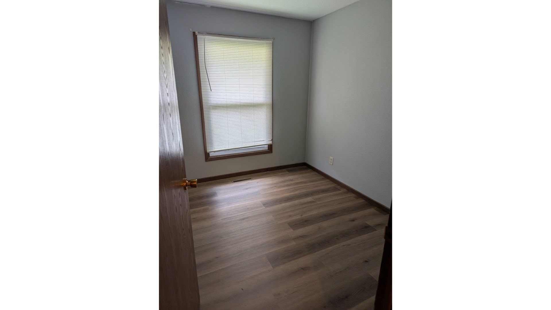 902 Shup Street Newton, IL 62448 - Photo 7 of 9 a view of an empty room with wooden floor and a window