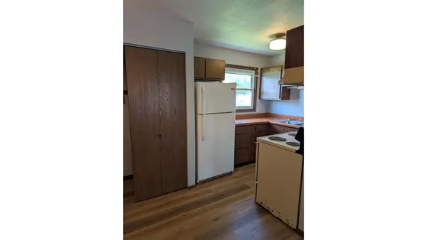 a kitchen with a refrigerator and a dresser