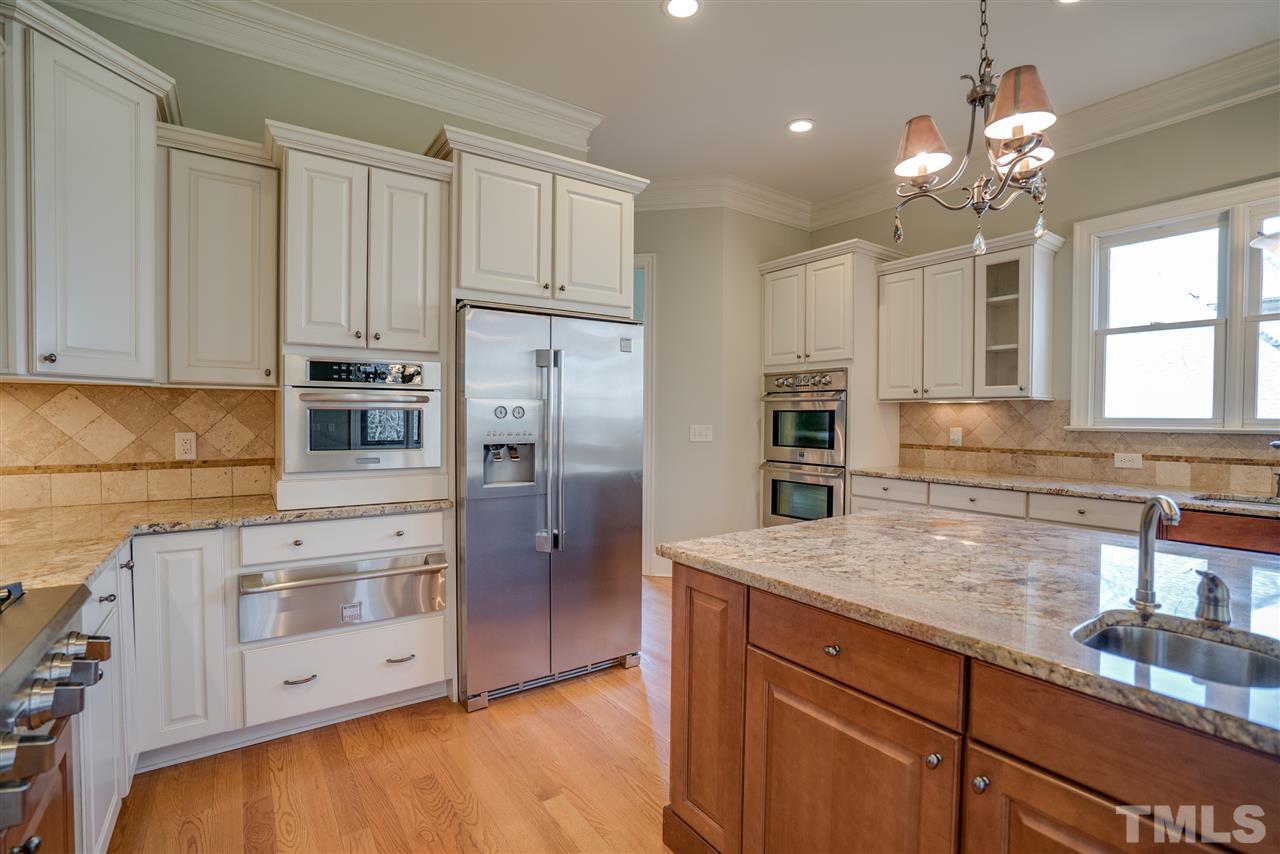 9008 Albatross Court Raleigh, NC 27613 - Photo 11 of 25 a kitchen with stainless steel appliances granite countertop a lot of counter space and wooden floors