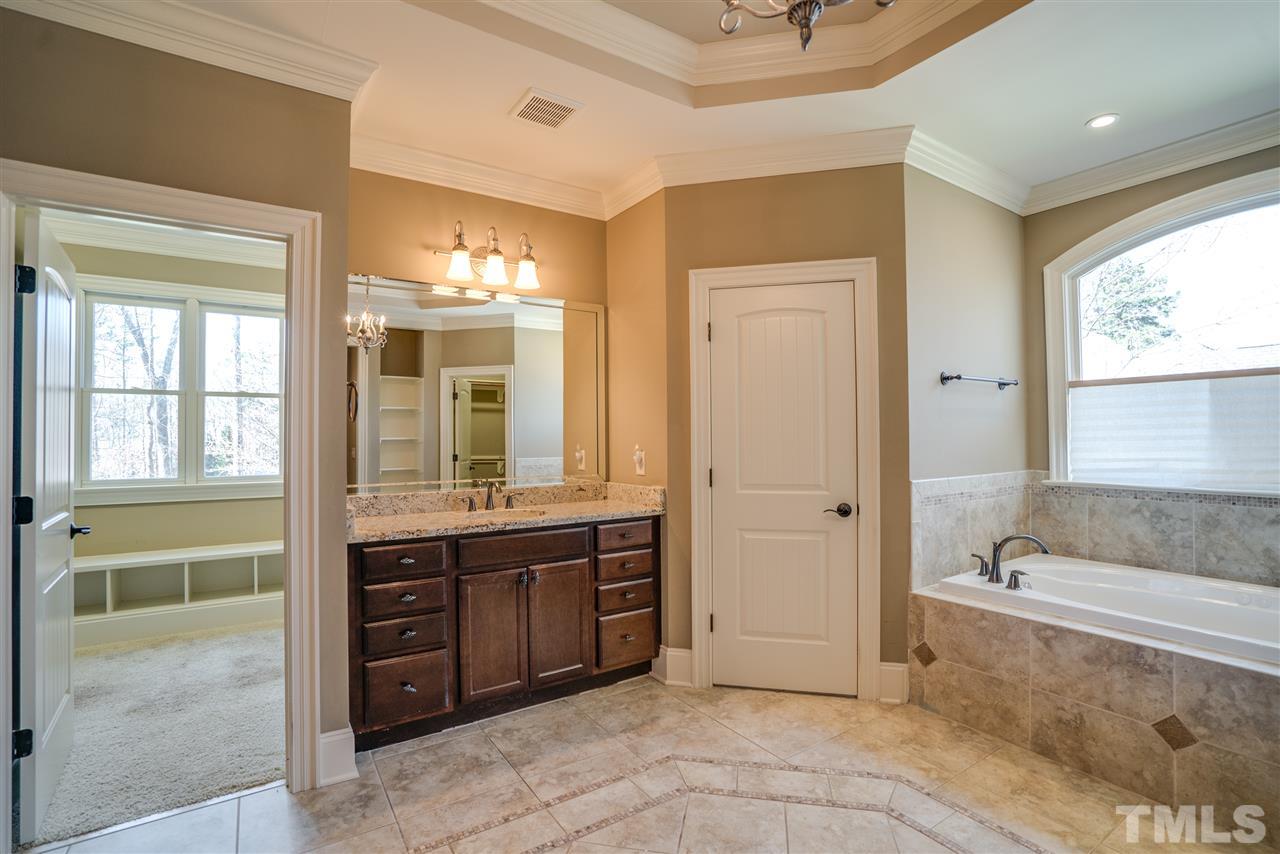 9008 Albatross Court Raleigh, NC 27613 - Photo 18 of 25 a spacious bathroom with a tub sink and mirror