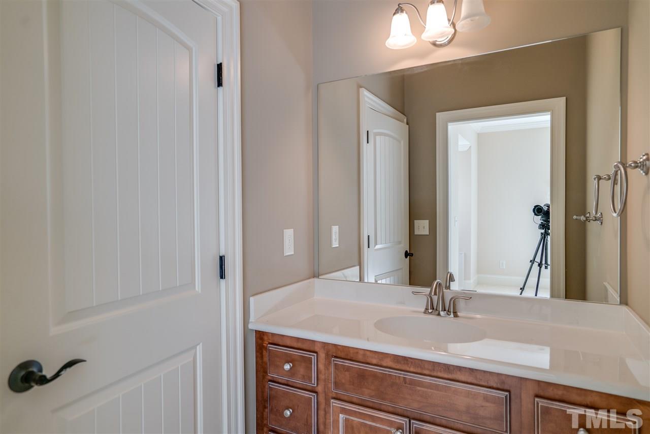 9008 Albatross Court Raleigh, NC 27613 - Photo 23 of 25 a bathroom with a granite countertop sink and a mirror