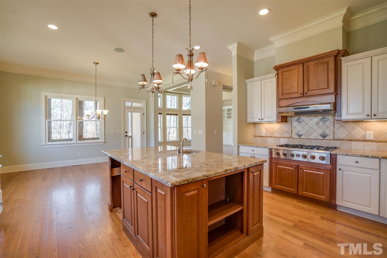 9008 Albatross Court Raleigh, NC 27613 - Photo 3 of 25 a kitchen that has a lot of cabinets and wooden floor