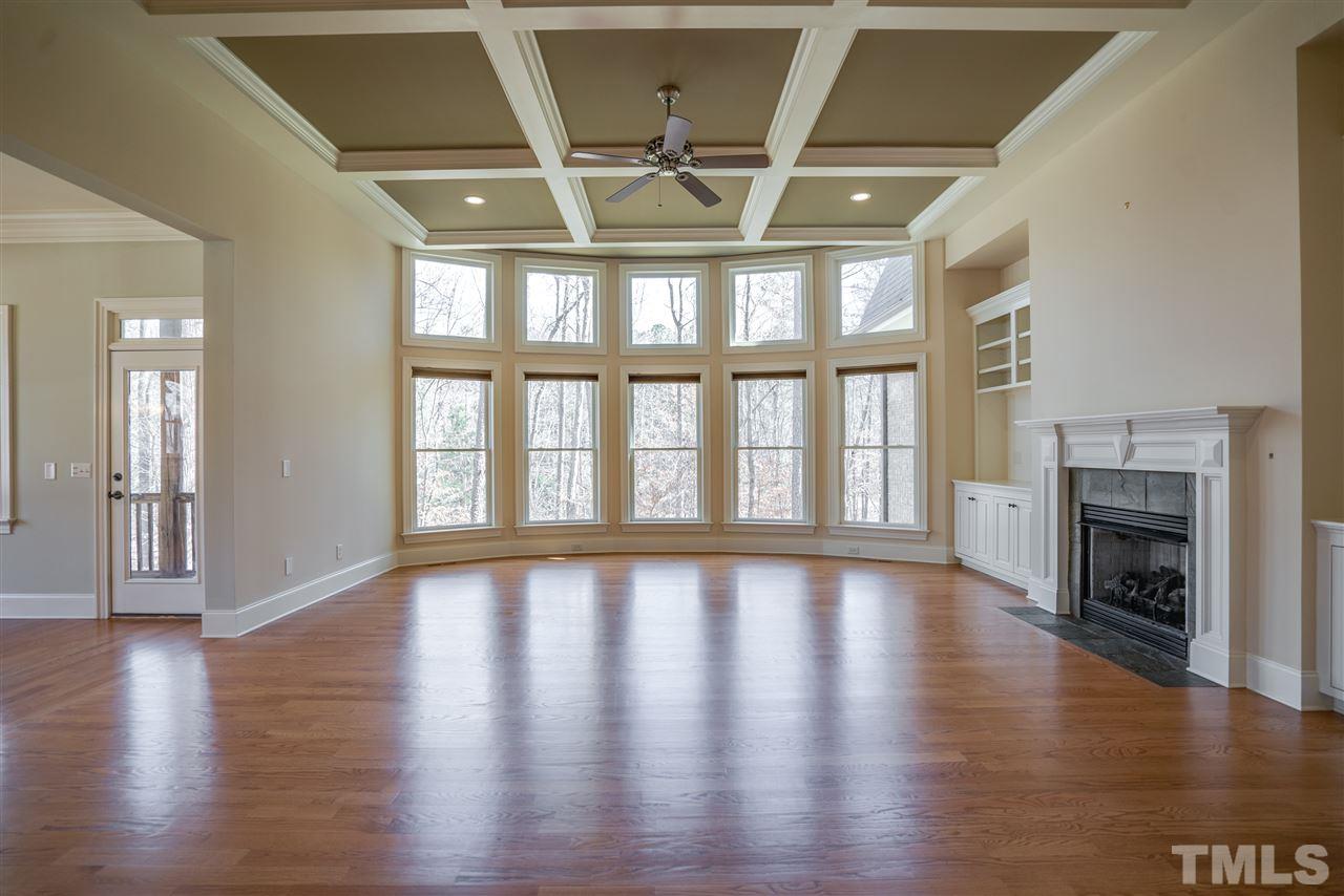 9008 Albatross Court Raleigh, NC 27613 - Photo 4 of 25 a view of an empty room with wooden floor and a fireplace