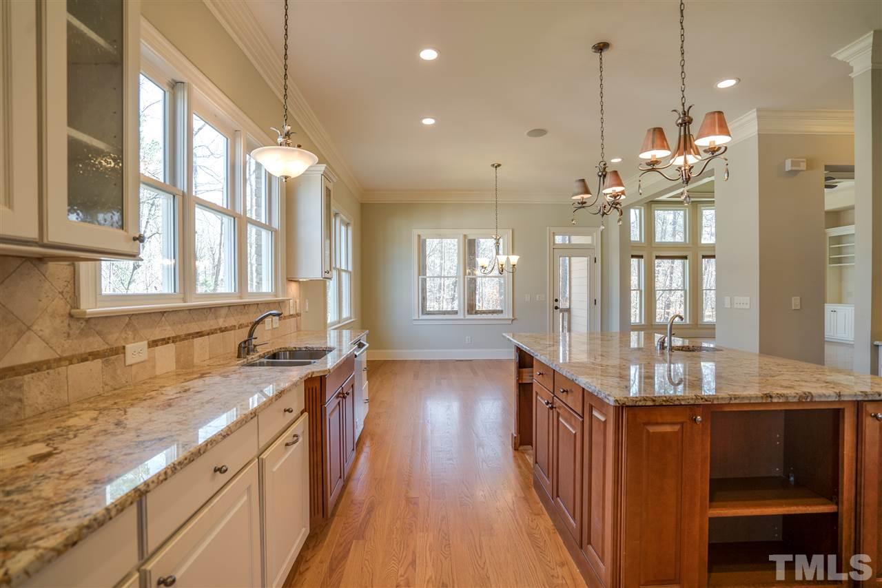 9008 Albatross Court Raleigh, NC 27613 - Photo 9 of 25 a kitchen with stainless steel appliances granite countertop a stove and cabinets