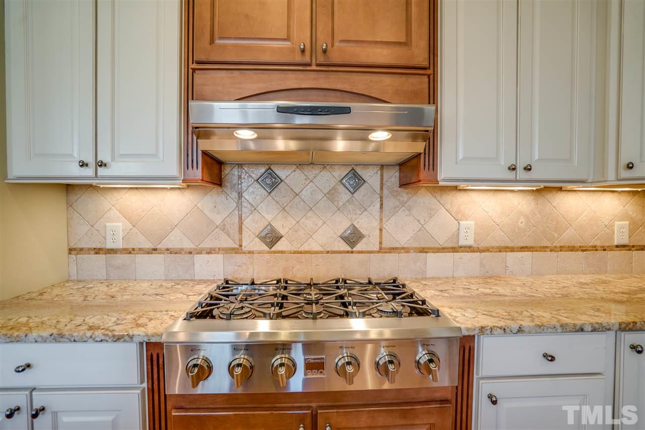 9008 Albatross Court Raleigh, NC 27613 - Photo 10 of 25 a stove top oven sitting inside of a kitchen
