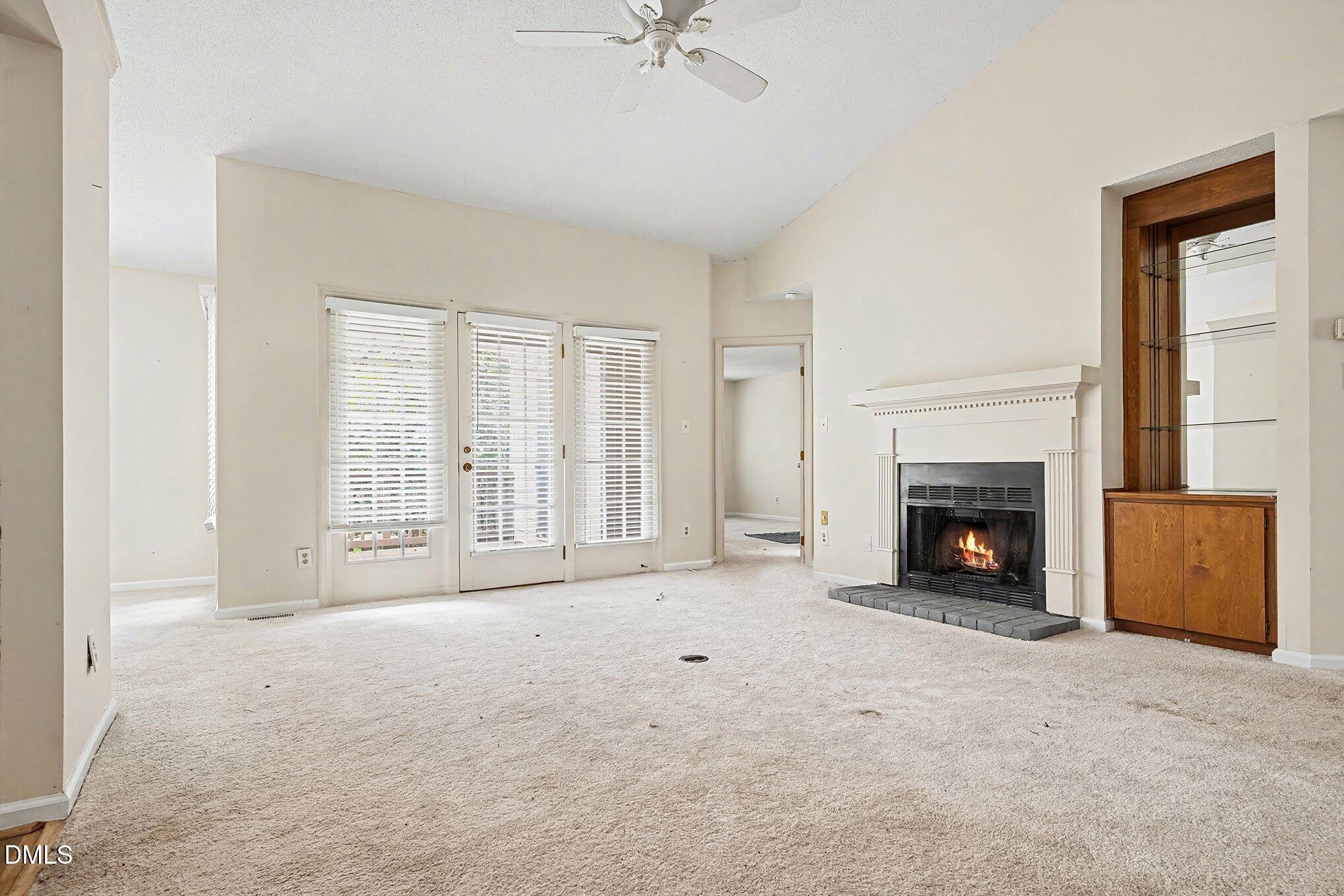 1201 Deptford Court Raleigh, NC 27609 - Photo 3 of 20 a view of an empty room with a fireplace and a window