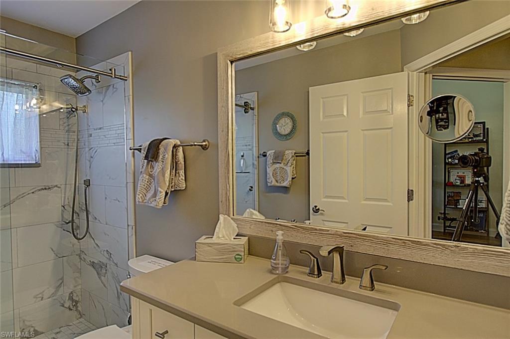6706 Mill Run Road Naples, FL 34109 - Photo 12 of 20 a bathroom with a sink and a mirror
