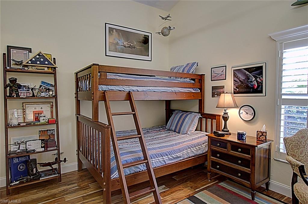 6706 Mill Run Road Naples, FL 34109 - Photo 13 of 20 a bedroom with a bed and a bookshelf
