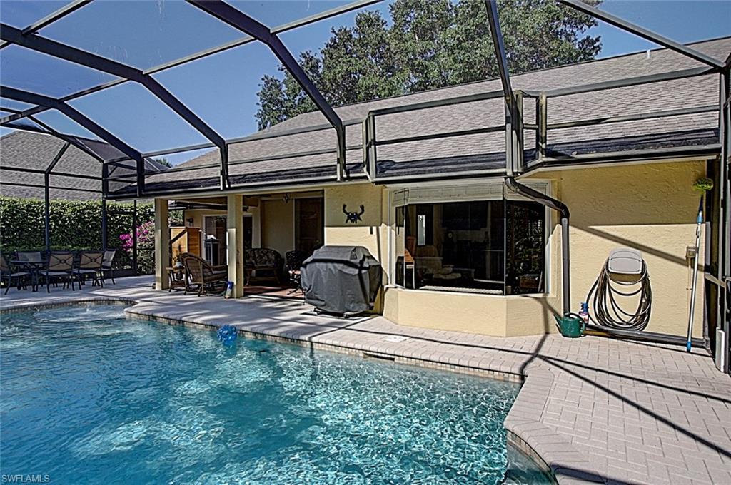6706 Mill Run Road Naples, FL 34109 - Photo 19 of 20 a view of a patio with table and chairs under an umbrella