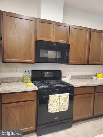 a kitchen with stainless steel appliances wooden cabinets a sink and a refrigerator