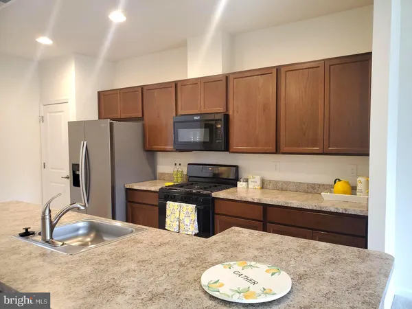 a kitchen with stainless steel appliances granite countertop a sink a stove and a refrigerator