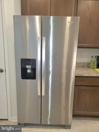 a large living room with stainless steel appliances granite countertop a couch and a view of kitchen