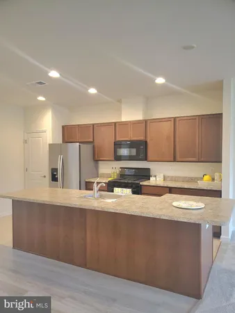a kitchen with a sink a refrigerator a microwave and cabinets