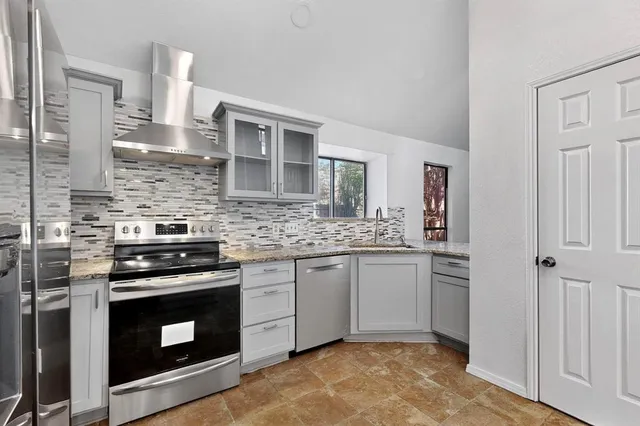 a kitchen with stainless steel appliances granite countertop a stove and a sink