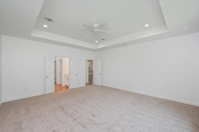 an empty room with a ceiling fan and natural light