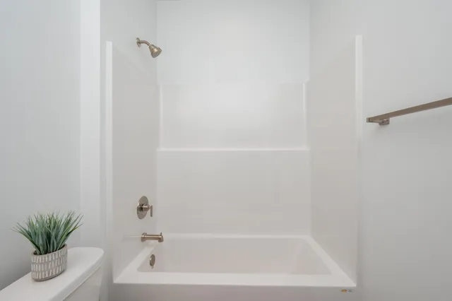 a view of an empty room and chandelier fan