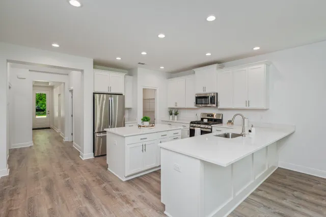 a bathroom with kitchen island a sink stainless steel appliances and cabinets