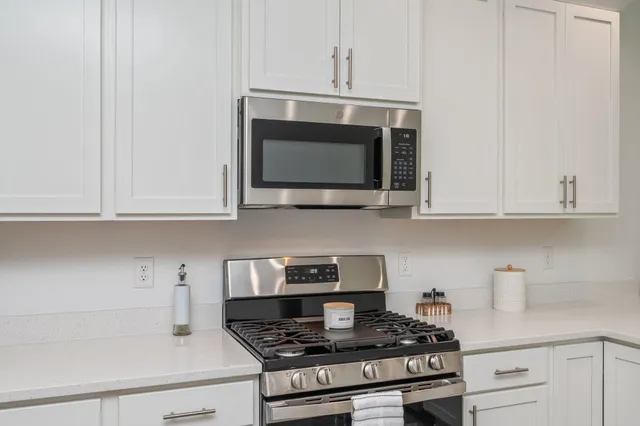 a kitchen with kitchen island a large counter top a stove and a window