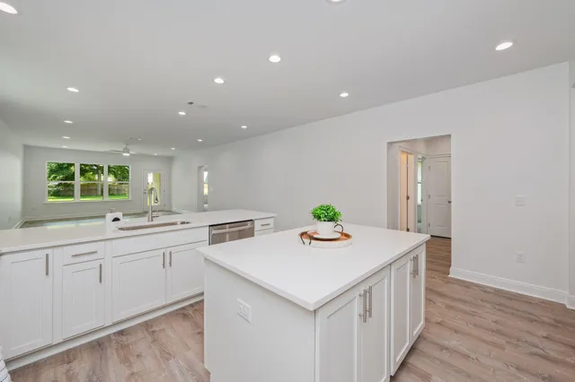 a kitchen with stainless steel appliances kitchen island granite countertop a refrigerator and a sink