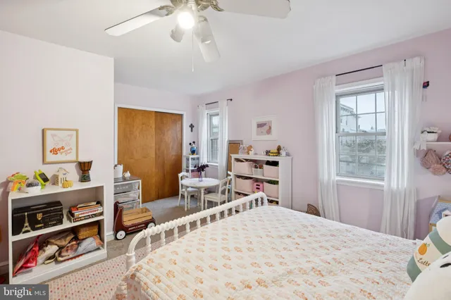 a bedroom with a bed a chandelier and dresser