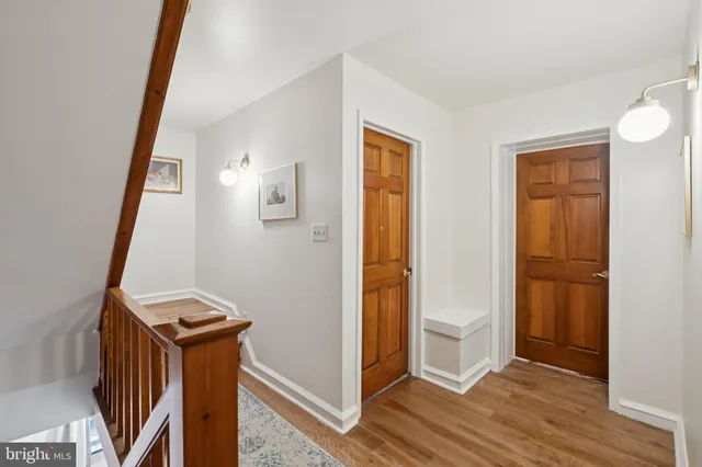 a view of a hallway with wooden floor and entryway