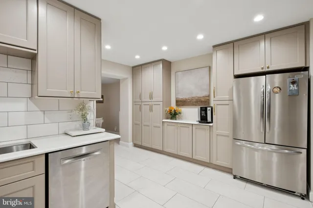 a kitchen with white cabinets and refrigerator
