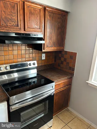 a stove top oven sitting inside of a kitchen