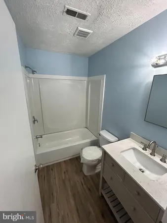 a bathroom with a sink a toilet a mirror and shower