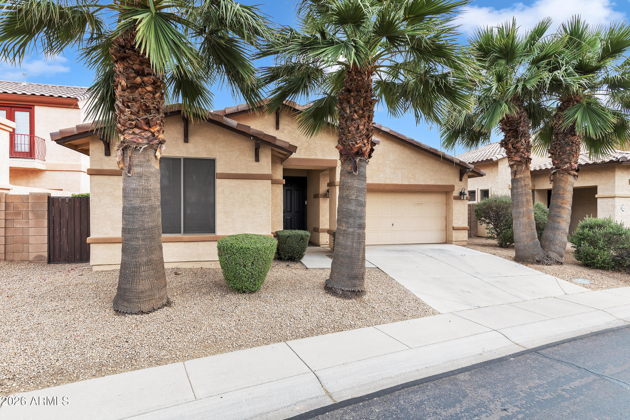 a view of a house with small yard and palm trees