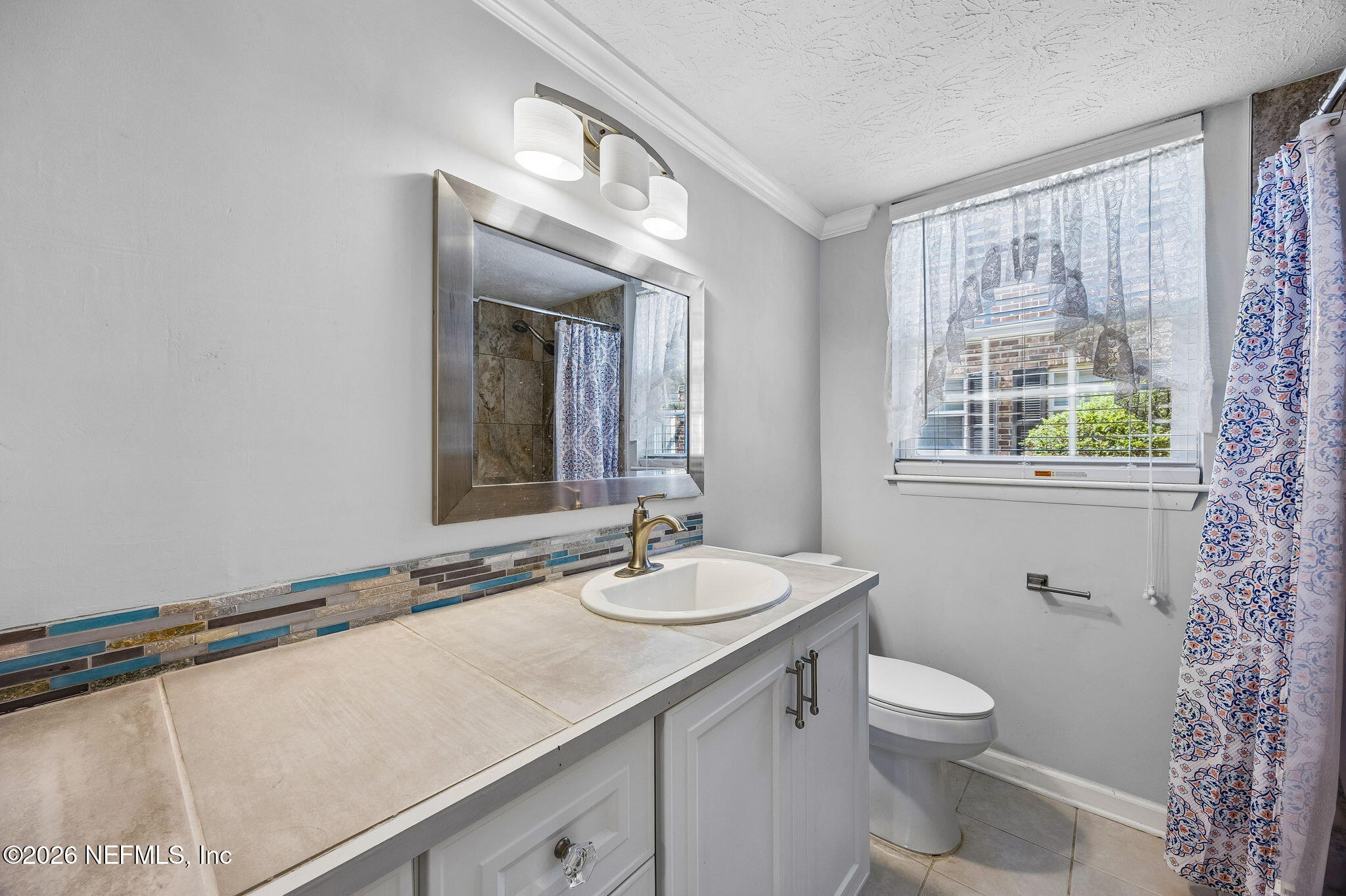 4358 Timuquana Road, Unit 134 Jacksonville, FL 32210 - Photo 12 of 31 a bathroom with a granite countertop sink mirror and a toilet