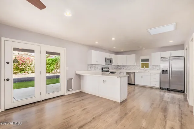 a kitchen with white cabinets and white appliances