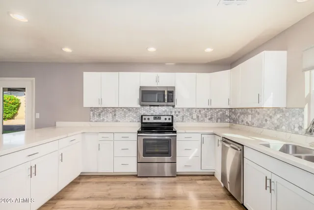 a kitchen with stainless steel appliances granite countertop a stove sink and cabinets