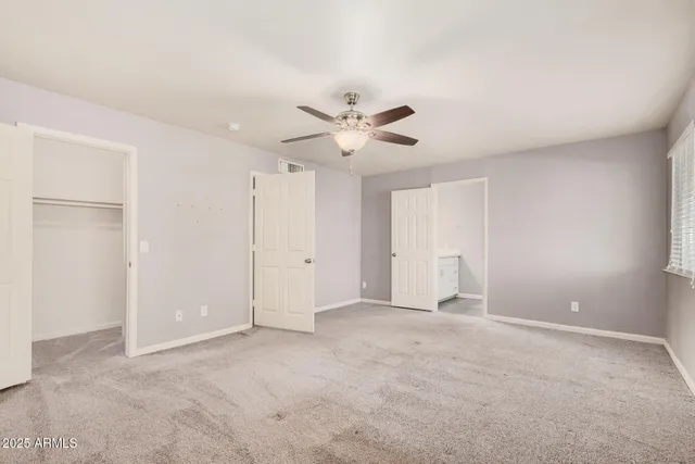 a view of an empty room with a ceiling fan