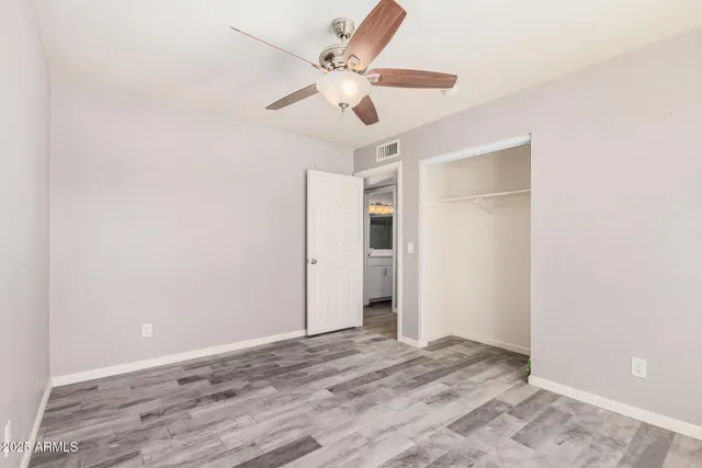 a view of a livingroom with a ceiling fan & hardwood floor