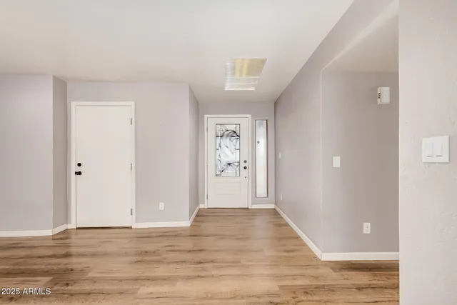a view of an empty room with wooden floor