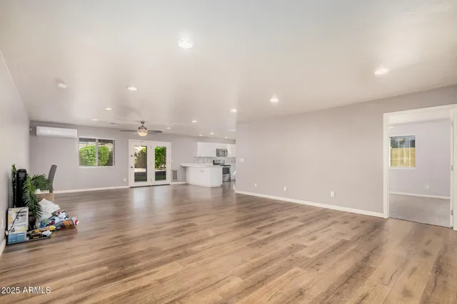 an empty room with wooden floor and windows