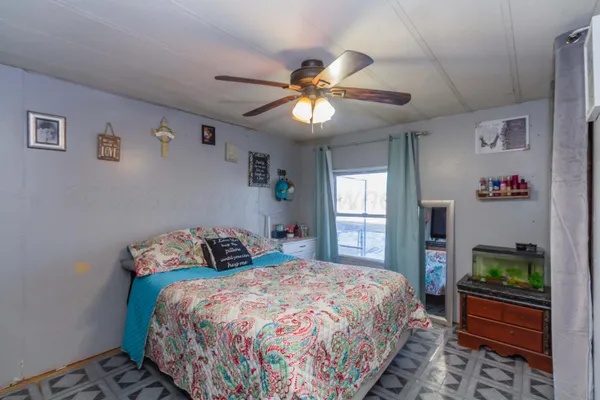 a bedroom with a bed and ceiling fan