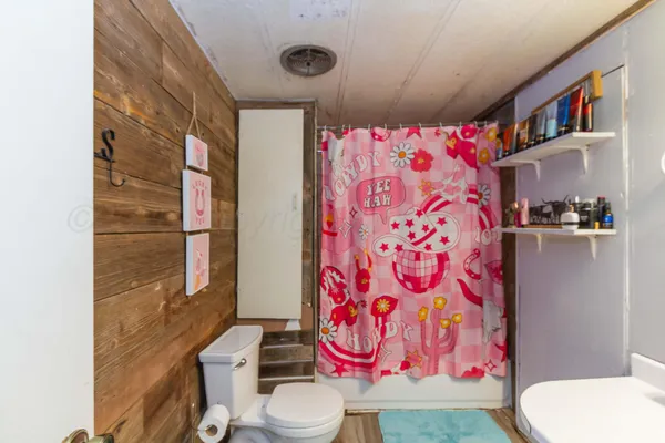 a bathroom with a toilet and shower curtain