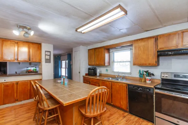a kitchen with a table chairs sink and cabinets