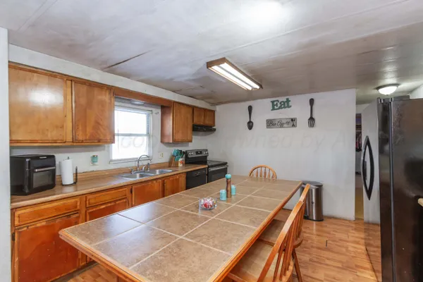 a kitchen with granite countertop a sink stove and refrigerator