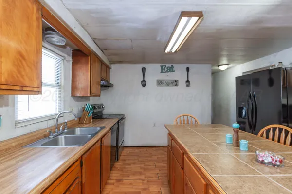 a kitchen with stainless steel appliances granite countertop a sink window and cabinets