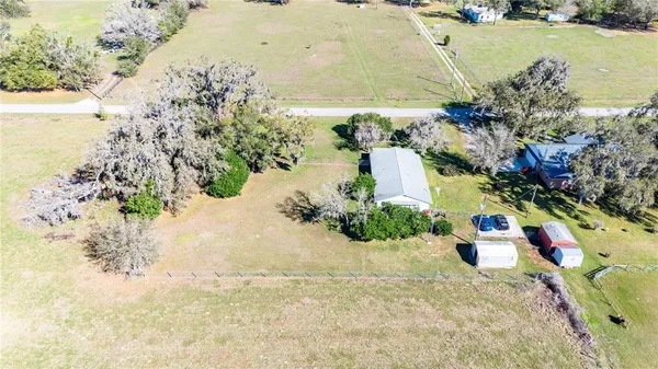 a aerial view of a house with swimming pool and large trees