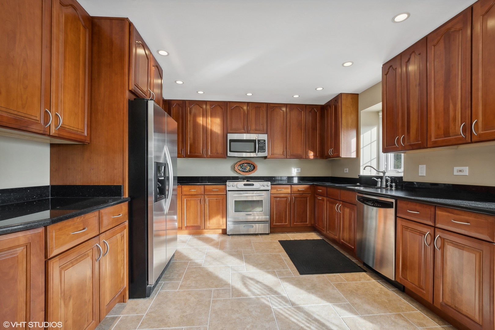 8669 Raintree Lane Orland Park, IL 60462 - Photo 6 of 25 a kitchen with stainless steel appliances granite countertop wooden cabinets a stove top oven a sink and dishwasher