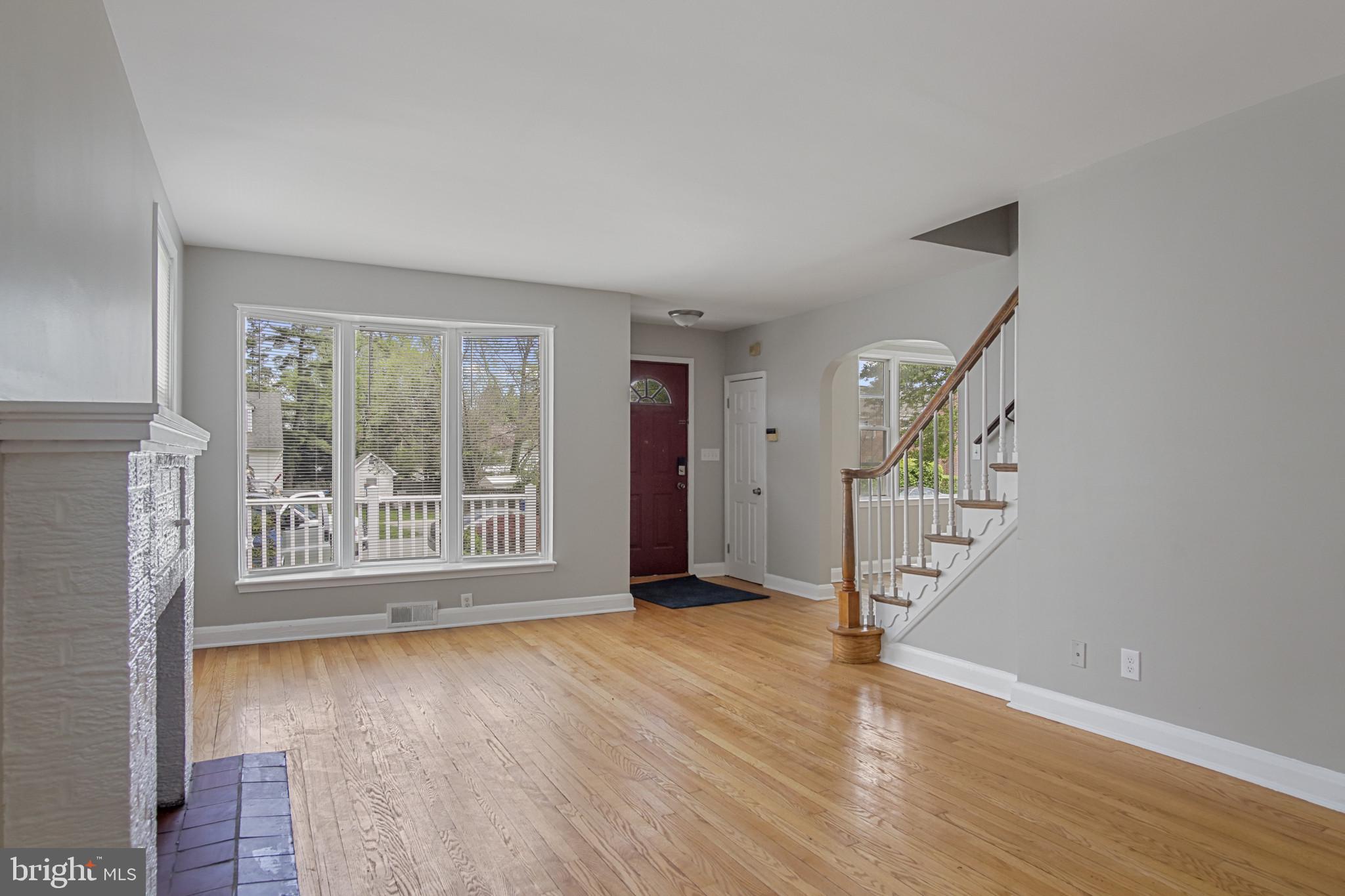 608 Farmhurst Road Baltimore, MD 21208 - Photo 7 of 45 a view of an empty room with wooden floor and a window