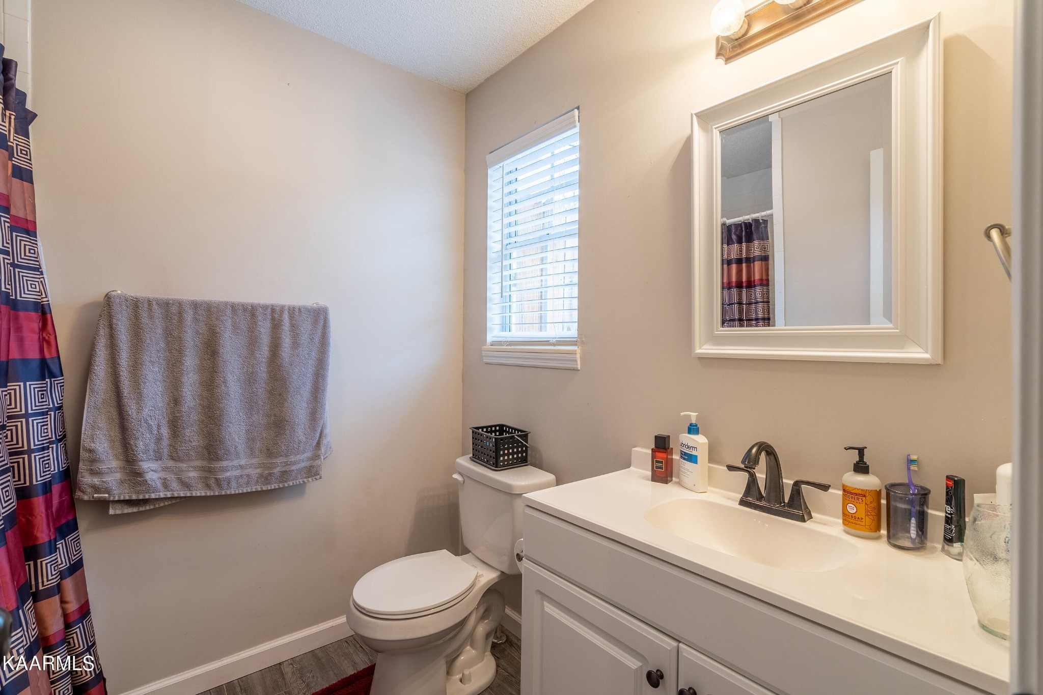 6408 Wilmouth Run Road Knoxville, TN 37918 - Photo 20 of 29 a bathroom with a granite countertop sink a mirror and a toilet